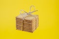 rectangle butter biscuits stacked and tied with jute rope, levitating on yellow background