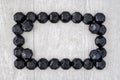 Rectangle frame of coal shaped candy on a gray washed wood background