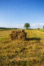 Rectangle shaped bales of straw on farmland with blue beautiful sky, harvesting Royalty Free Stock Photo