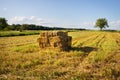 Rectangle shaped bales of straw on farmland with blue beautiful sky, harvesting Royalty Free Stock Photo