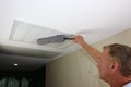 Dusting HVAC Intake Vent Grid By Adult Man to Reduce Allergens