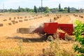Rectangular baler discharges straw bale in a field during the harvesting process Royalty Free Stock Photo