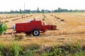 Rectangular baler discharges straw bale in a field during the harvesting process Royalty Free Stock Photo