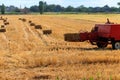 Rectangular baler discharges straw bale in a field during the harvesting process Royalty Free Stock Photo