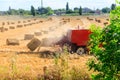 Rectangular baler discharges straw bale in a field during the harvesting process Royalty Free Stock Photo