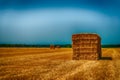 Rectangular bales of straw stacked on a stubble field in dramatic colors Royalty Free Stock Photo