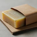 Rectangular bar of handmade soap partially wrapped in brown kraft paper. The soap h Royalty Free Stock Photo