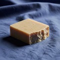 A rectangular bar of handmade soap is placed on a textured blue Royalty Free Stock Photo