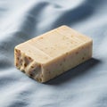 Rectangular bar of light beige soap rests on a soft, textured blue Royalty Free Stock Photo