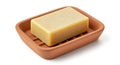 A rectangular bar of light beige soap rests in a terracotta-colored soap dish made of Royalty Free Stock Photo