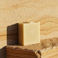 A rectangular bar of soap with a smooth, light beige surface sits on a sandstone ledg Royalty Free Stock Photo