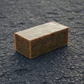 Rectangular bar of soap on a textured, dark asphalt surface. The soap is a light brown Royalty Free Stock Photo
