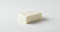 A rectangular bar of white soap with beveled edges rests on a smooth, plain white Royalty Free Stock Photo