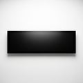 A rectangular black frame hangs centered on a plain white wall Royalty Free Stock Photo