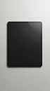A rectangular black tablet with rounded edges is placed on a light gray, textured Royalty Free Stock Photo