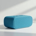 Rectangular blue portable speaker with rounded edges, featuring a mesh fabric cover. Royalty Free Stock Photo