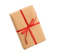 Rectangular box wrapped in brown paper and tied with a red bow, gift isolated on white background Royalty Free Stock Photo