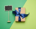 Rectangular box wrapped in brown paper and tied with a silk blue ribbon with a bow Royalty Free Stock Photo