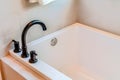 Rectangular built in bathtub inside bathroom of a home with white tiles wall Royalty Free Stock Photo