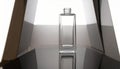 Rectangular clear glass bottle on a dark reflective surface with dramatic lighting empty Royalty Free Stock Photo