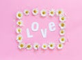 Rectangular daisies frame on a pink background and text LOVE Royalty Free Stock Photo