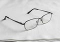 Rectangular eyeglasses with thin black metal frames rest on a Royalty Free Stock Photo