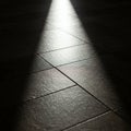 Rectangular floor tiles with a textured surface are illuminated by a focused beam of Royalty Free Stock Photo