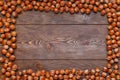 rectangular frame of many hazelnuts with shells on brown wooden surface Royalty Free Stock Photo