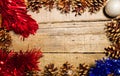 Rectangular frame of pine cones with red and blue tinsel and a silver ball on an old table with a great wooden texture. Ideal for Royalty Free Stock Photo