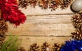 Rectangular frame of pine cones and red tinsel on an old table with a great wooden texture. Ideal for Christmas Royalty Free Stock Photo