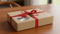 A rectangular gift box wrapped in light brown paper sits on a wooden Royalty Free Stock Photo