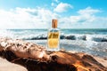 Rectangular glass bottle of golden perfume standing on a coastal driftwood. Ocean waves and sunny sky in the background