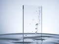 A rectangular glass pane stands vertically in a pool of clear water Royalty Free Stock Photo