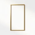 A rectangular gold picture frame hangs against a plain white wall Royalty Free Stock Photo