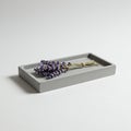 A rectangular, gray concrete tray holds a small bundle of lavender Royalty Free Stock Photo