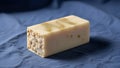 Rectangular handmade soap bar resting on a blue fabric surface Royalty Free Stock Photo