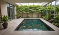 rectangular indoor pool with orange koi fish swimming in tranquil green water, surrounded by lush greenery Royalty Free Stock Photo