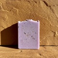 Rectangular lavender soap bar with irregular edges, speckled with small dark particles Royalty Free Stock Photo