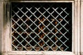 Rectangular metal lattice in front of a window on the facade of the building. Close-up Royalty Free Stock Photo