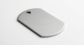 Rectangular metallic dog tag with rounded edges, lying on a white surface. The tag features a Royalty Free Stock Photo