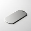 Rectangular metallic tag with rounded edges and a small hole at one end, placed on a smooth white Royalty Free Stock Photo