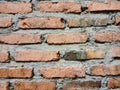 Rectangular patterned orange brick wall with rough-textured gray cement