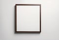 A rectangular picture frame with a dark brown wenge oak finish, mounted vertically on a light gray wall Royalty Free Stock Photo