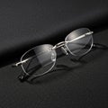 Rectangular rimless eyeglasses placed on a textured black surface Royalty Free Stock Photo
