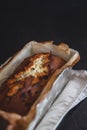 Rectangular ruddy metropolitan cake-bread in a metallic baking dish on a dark background. Close-up. View from above. Copy space Royalty Free Stock Photo