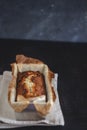 Rectangular ruddy metropolitan cake-bread in a metallic baking dish on a dark background. Close-up. View from above. Copy space Royalty Free Stock Photo