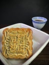A Red bean moon cake served with tea on wooden background . Royalty Free Stock Photo