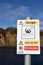 Sign warning of deep cold water, danger of drowning. Multiple icons indicating not to swim. Inverkeithing quarry, Fife, Scotland.