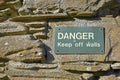 Danger keep off walls sign on ancient stone wall at Balmerino Abbey, Fife Scotland, UK Royalty Free Stock Photo