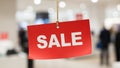 Rectangular sign with the word SALE in bold white letters hangs Royalty Free Stock Photo